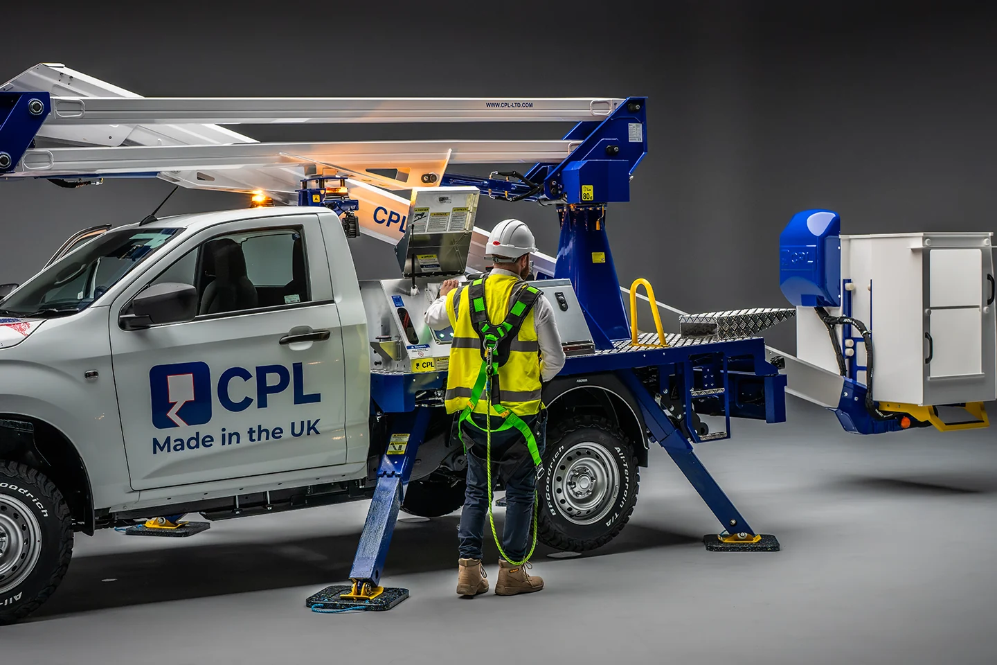 Operator using controls on a CPL vehicle-mounted MEWP at height