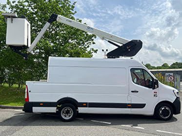 White van chassis with a Klubb boom raised over the cab and a basket at the rear, parked on tarmac
