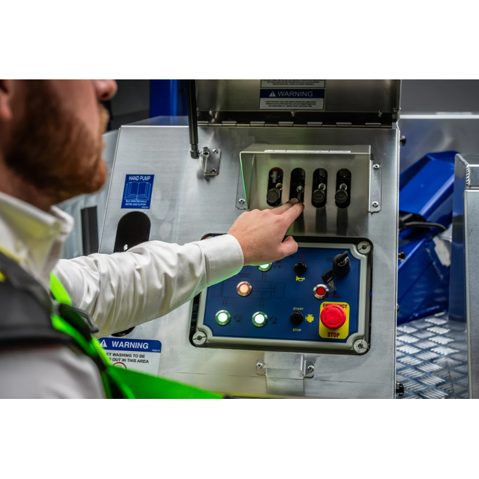 Operator operating the ground controls of a CPL MEWP showing start, stop and emergency stop buttons